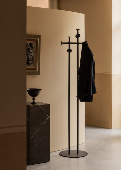 Audo Copenhagen Afteroom Coat Stand in powder coated black beside a tall Plinth and a Pavot bowl