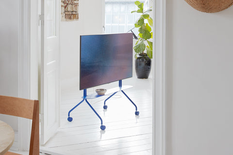Pedestal Moon TV Stand in Ultra Marine, seen through a doorway in a bright white room