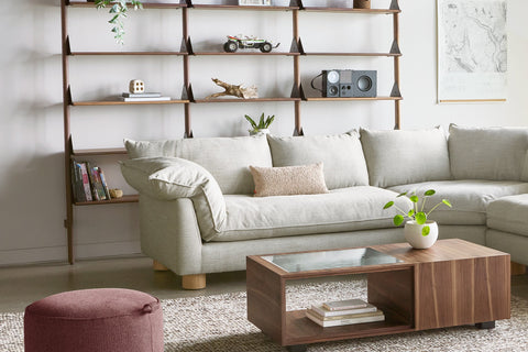 Gus* Modern Zoe Bi-Sectional in Sutton Canvas with a Conway Coffee Table in Natural Walnut, below Branch shelving in walnut
