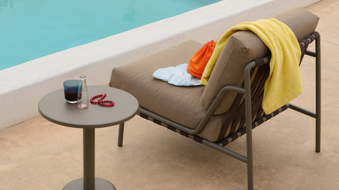 Settle Outdoor Lounge Chair by Anderssen & Voll for Muuto in taupe with steel frame, styled poolside with a side table