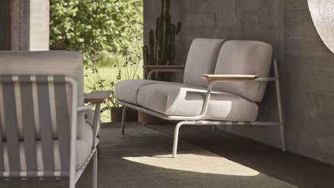 Settle Outdoor Sofa by Anderssen & Voll for Muuto with steel frame, mahogany armrests, and taupe cushions on a patio