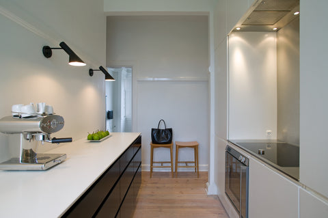 black aj wall lamp mounted in bathroom by louis poulsen