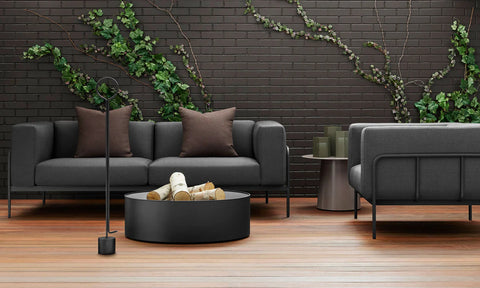 Blu Dot Cache Lounge Chair and Sofa in Sunbrella Coal styled on an outdoor deck with fire pit