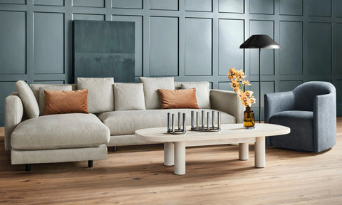Blu Dot Good Times oval coffee table in white oak styled in a modern living room with a linen sectional sofa and blue swivel chair