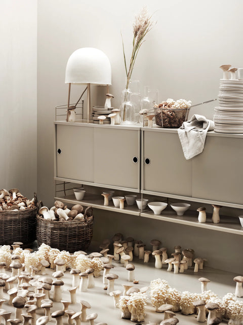 String Furniture cabinet with sliding doors in beige, Scandinavian modular storage styled with ceramics and natural decor