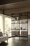 String Furniture Pira shelving with walnut bookends and cabinets, black grey steel shelving in a dark living room
