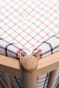 Close up of oak corner and plaid cushion with leather lacing on Fredericia Spokeback Sofa by Borge Mogensen