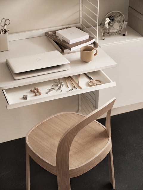 White String® desk drawer integrated into modular shelving system, styled with laptop, books, and accessories in a Scandinavian home office setup.