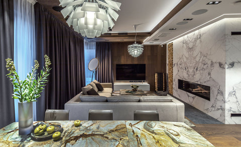 Louis Poulsen PH Artichoke pendants in a modern Scandinavian living and dining room with marble fireplace and grey sectional sofa