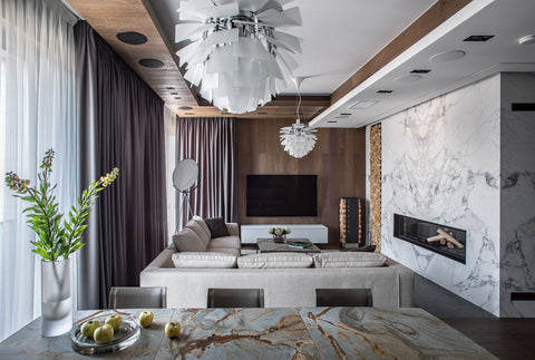 Louis Poulsen PH Artichoke chandelier over a contemporary living room with marble feature fireplace and neutral sectional