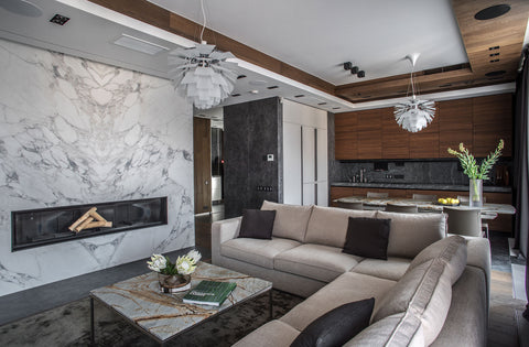 Pair of PH Artichoke pendants lighting an open concept living room and walnut kitchen with veined marble accent wall