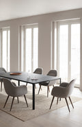 Swoon Dining Chairs with dark wood legs and grey upholstery arranged around a black rectangular dining table.