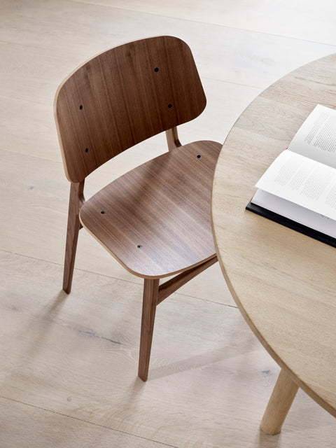 Søborg Chair in walnut veneer beside an oak dining table top view
