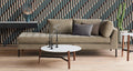 Blu Dot Free Range Coffee Table styled in a modern living room with a tan velvet daybed sofa and geometric patterned wallpaper