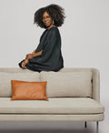 Blu Dot Bloke 95" Sofa in light grey fabric with thin steel legs styled with a cognac leather lumbar pillow