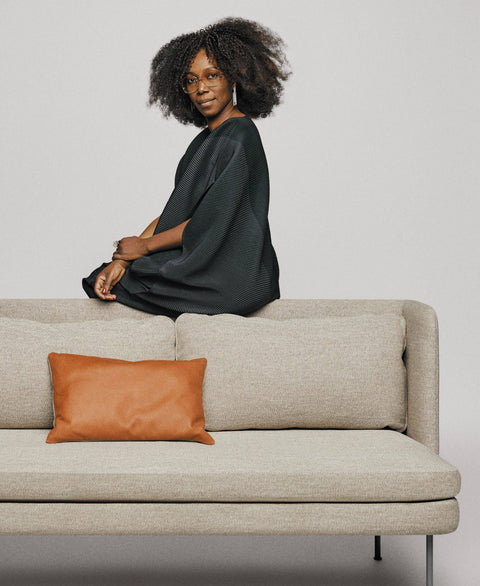 Blu Dot Bloke 95" Sofa in light grey fabric with thin steel legs styled with a cognac leather lumbar pillow