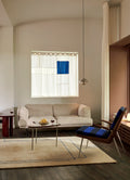 Modern interior with &Tradition Pinwheel HM7 End Table in walnut and stainless steel beside beige sofa and armchair