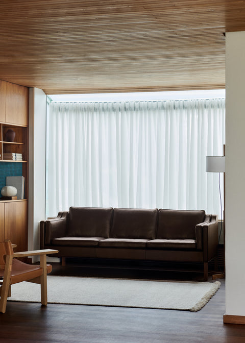 Mogensen 2213 leather sofa styled in a Nordic interior with floor to ceiling curtains