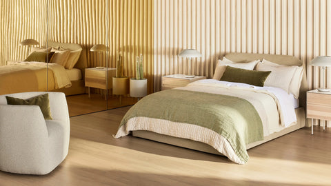 Blu Dot Beau Table Lamp in putty styled on a nightstand in a warm modern bedroom setting