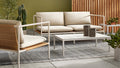 Blu Dot Dog Days Outdoor 2 Seat Sofa in Sunbrella Linen cushions with white powder-coated aluminum frame and all-weather rattan, styled on a patio with matching lounge chair, coffee table, and cacti