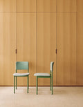 Fredericia Plan Chair in green frame with light upholstery against oak wall background