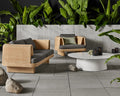 Loophole Outdoor 3 Seat Sofa and Lounge Chair by Blu Dot in Toohey Charcoal, styled on an outdoor patio with tropical plants