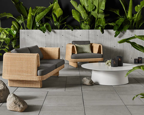 Loophole Outdoor 3 Seat Sofa and Lounge Chair by Blu Dot in Toohey Charcoal, styled on an outdoor patio with tropical plants