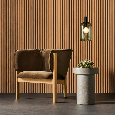 Blu Dot All In Lounge Chair in brown velvet with natural oak frame styled beside a stone side table and pendant light against a wood slat wall