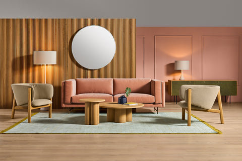 Blu Dot All In Lounge Chairs in cream boucle flanking a dusty rose sofa, styled with oval wood coffee tables and a round mirror in a modern living room