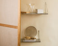 Frama Single Shelf, Stainless Steel, two shelves past a linen and wood screen, glass vase above and a round tray below