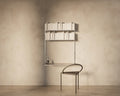 Frama Shelf Library Desk Section in Stainless Steel, steel shelf of books above a desk shelf with a dark curved back chair pulled up to it