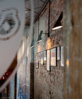 aj wall lamp by louis poulsen mounted on brick wall in restaurant 