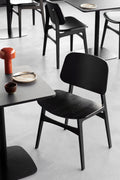 Søborg Chair black stained oak in a modern cafe setting by Fredericia