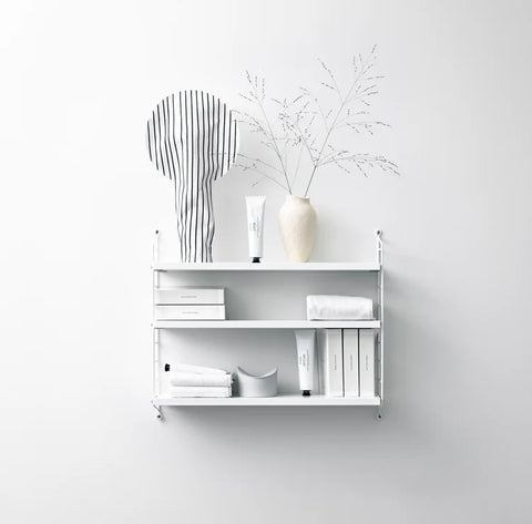 White String® Pocket shelf styled in a bathroom with towels, skincare, and a ceramic vase – Scandinavian modular shelving