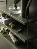 Olive green String® Pocket shelf styled with glass vase, greenery, and decorative objects – Scandinavian wall-mounted shelving