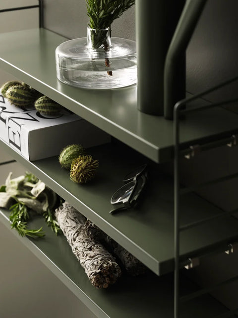 Olive green String® Pocket shelf styled with glass vase, greenery, and decorative objects – Scandinavian wall-mounted shelving
