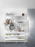 White String® System modular shelving with metal shelves high, styled in a kitchen with cookware, dishes, and fresh vegetables.