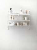 String® Pocket Metal shelf in white, Scandinavian wall-mounted shelving styled with bathroom accessories.