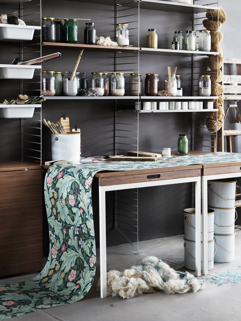Walnut String® folding table with shelving in creative studio workspace