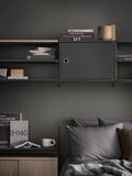 Dark grey Cabinet with Swing Door integrated into String® System shelving above bed