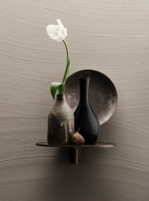 Museum NM&.045 shelf by String™ in dark brown styled with ceramic vases, plate, fig, and tulip against textured wall