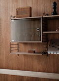 String Furniture wall-mounted shelving with walnut cabinet and glass door for glassware storage