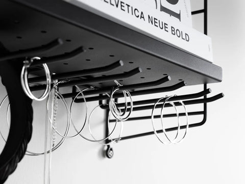 Close-up of String® Hanger Rack in black mounted under shelf holding jewelry and accessories