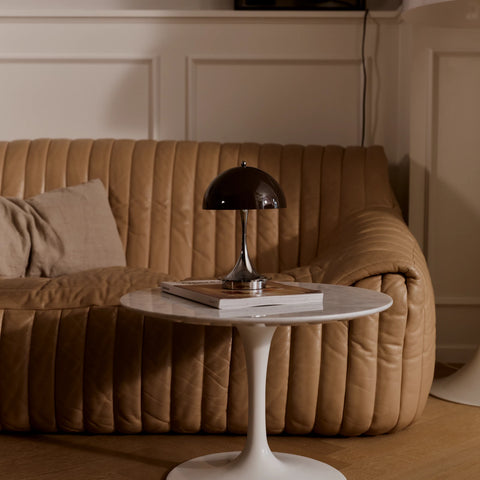 Louis Poulsen Panthella 160 portable lamp in brown turned off on a marble side table in a living room