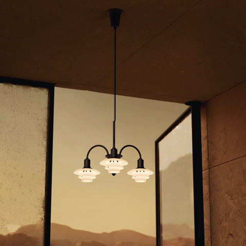 Louis Poulsen PH 1/1 Chandelier 3-arm configuration in matte black with opal glass shades hanging against floor-to-ceiling windows at dusk