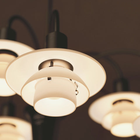 Close-up detail of Louis Poulsen PH 1/1 Chandelier opal glass shade showing layered disc construction and glare-free light diffusion