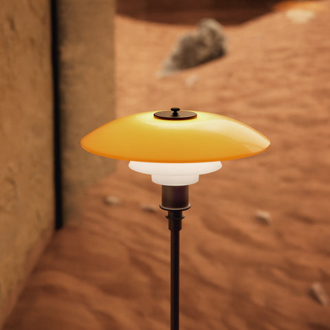 PH 3½-2½ Floor Lamp Centenary Edition by Louis Poulsen — illuminated amber and opal glass three-shade system glowing in warm earthy interior setting