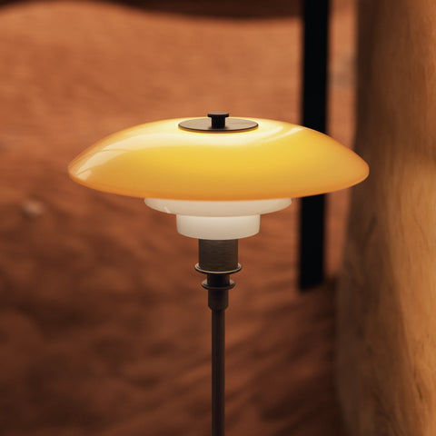 Close-up of the PH 3/2 Centenary Edition amber mouth-blown glass shade and aged brass hardware by Louis Poulsen