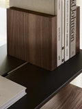 String Furniture Pira Bookend in walnut dividing books on a black steel shelf, detail