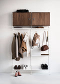 White String® System coat hangers in hallway setup with jackets, shoes, and storage cabinets.